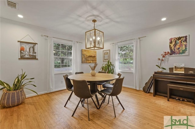 dining area featuring a chandelier, visible vents, a healthy amount of sunlight, and light wood-style floors