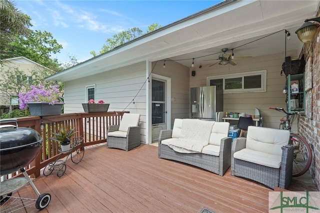 wooden deck featuring outdoor lounge area, area for grilling, and ceiling fan