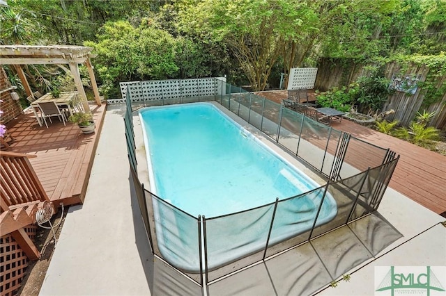 view of swimming pool featuring a fenced backyard, a wooden deck, and a fenced in pool
