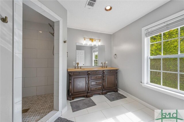 229 Golden Dr, Rincon, GA 31326 - bathroom with a tile shower, a sink, a wealth of natural light, and visible vents