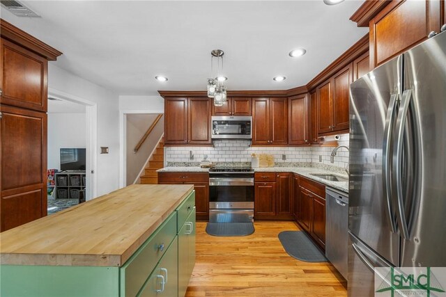 229 Golden Dr, Rincon, GA 31326 - kitchen with butcher block countertops, a sink, tasteful backsplash, light wood-style flooring, and appliances with stainless steel finishes
