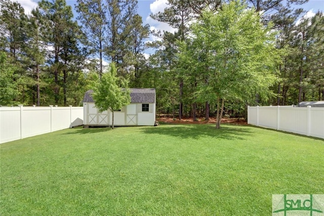 view of yard featuring a storage shed, a fenced backyard, and an outbuilding