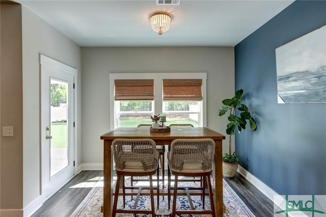dining space with a healthy amount of sunlight, wood finished floors, baseboards, and visible vents