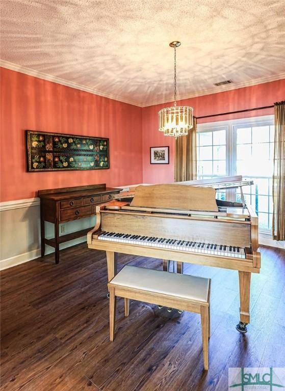 interior details with baseboards, a chandelier, crown molding, visible vents, and wood finished floors