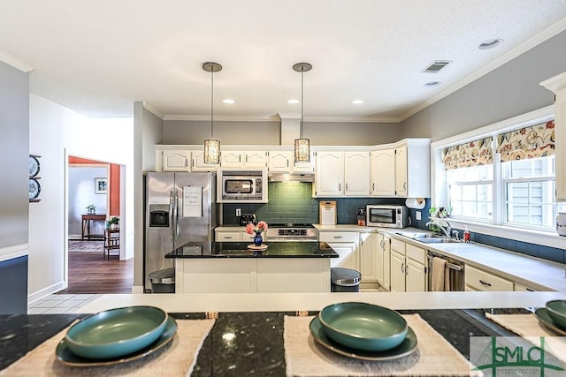 kitchen with tasteful backsplash, under cabinet range hood, visible vents, stainless steel appliances, and a sink
