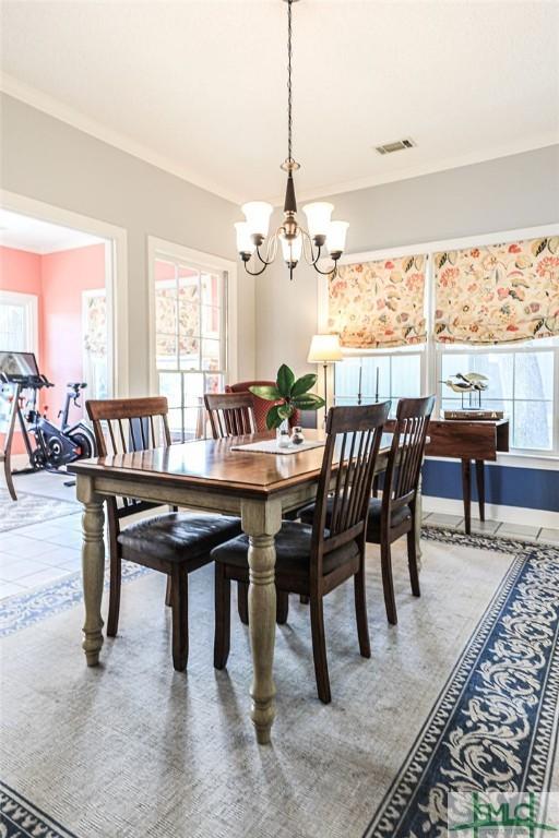 dining space featuring a chandelier, visible vents, and ornamental molding