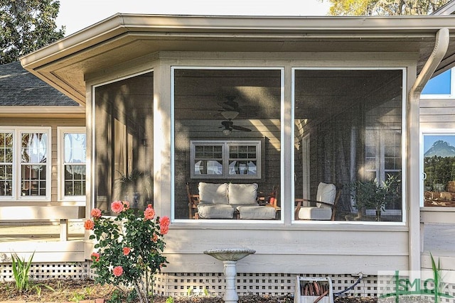 exterior space featuring roof with shingles and a sunroom