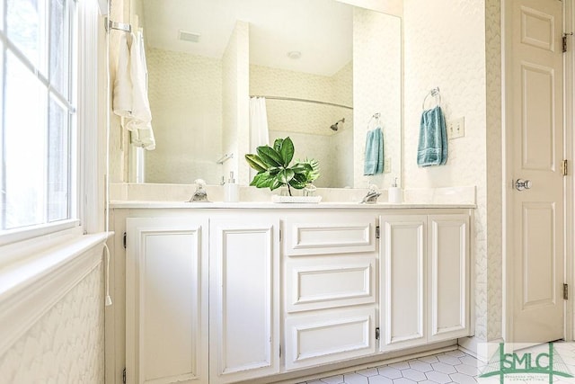 bathroom with visible vents, curtained shower, a sink, double vanity, and tile patterned flooring