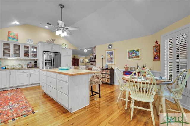 116 Brevard Ct, Savannah, GA 31410 - kitchen featuring stainless steel fridge with ice dispenser, vaulted ceiling, ceiling fan, light countertops, and a breakfast bar