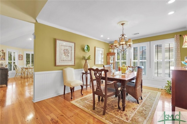 116 Brevard Ct, Savannah, GA 31410 - dining area with crown molding, healthy amount of natural light, a chandelier, a wainscoted wall, and light wood-style flooring