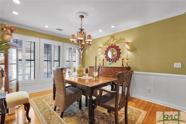 116 Brevard Ct, Savannah, GA 31410 - dining room with a chandelier, healthy amount of natural light, light wood-style flooring, wainscoting, and ornamental molding