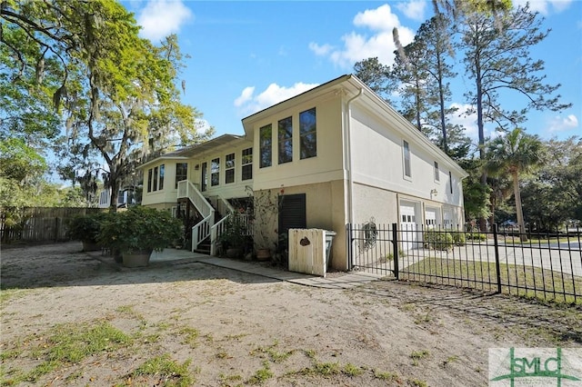 116 Brevard Ct, Savannah, GA 31410 - back of house with a garage, stucco siding, and stairs