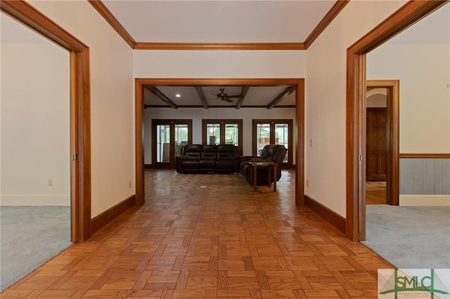 hall with beamed ceiling, light colored carpet, baseboards, and ornamental molding