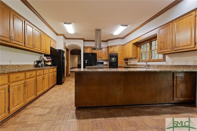 kitchen with dark stone counters, arched walkways, ornamental molding, black appliances, and island range hood
