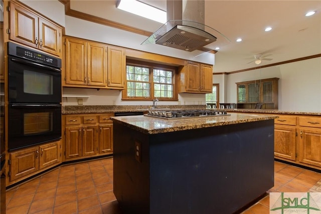kitchen with island exhaust hood, ornamental molding, tile patterned flooring, a kitchen island, and dobule oven black