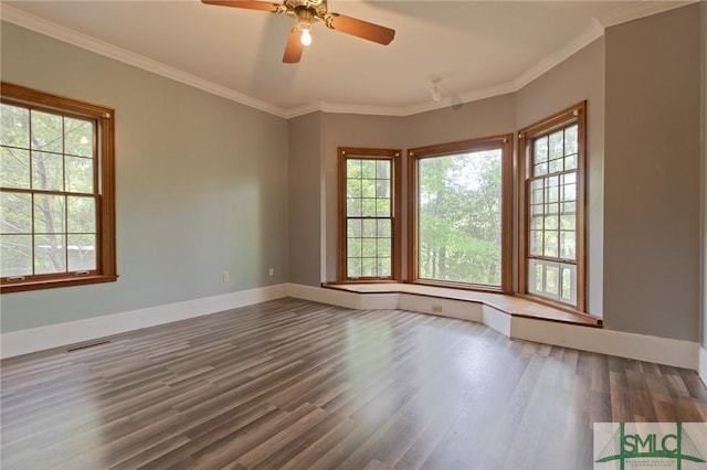 spare room featuring baseboards, wood finished floors, and a healthy amount of sunlight