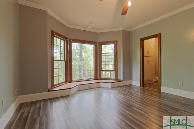 spare room featuring baseboards, wood finished floors, and a healthy amount of sunlight