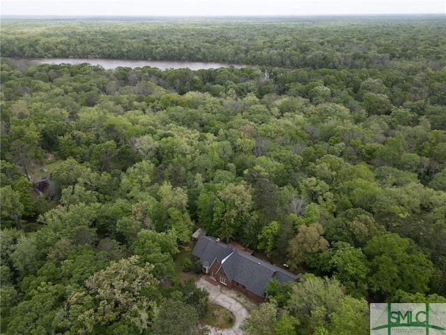 birds eye view of property with a view of trees and a water view