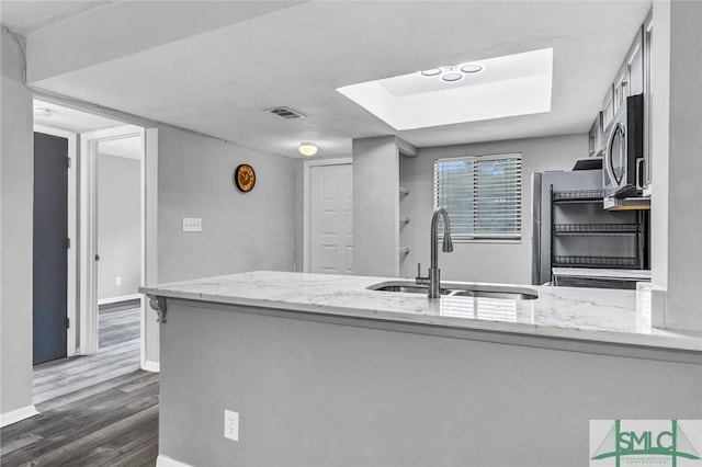 12510 White Bluff Rd Unit 1406, Savannah, GA 31419 - kitchen with light stone countertops, visible vents, stainless steel microwave, a sink, and dark wood-style floors