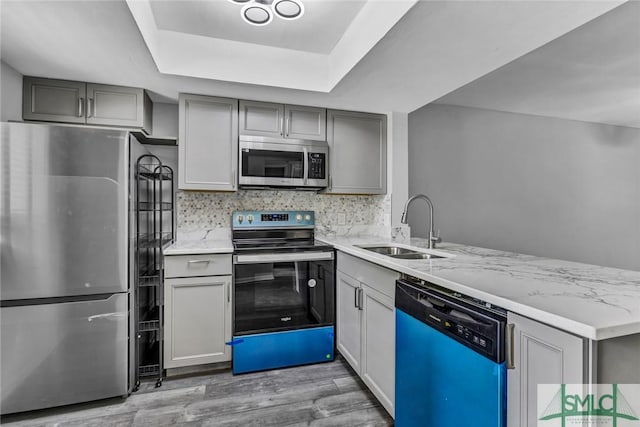 12510 White Bluff Rd Unit 1406, Savannah, GA 31419 - kitchen with light wood-style floors, gray cabinets, appliances with stainless steel finishes, a sink, and a raised ceiling