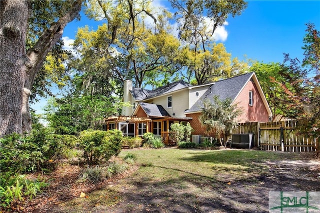 5 Wigmore Cir, Savannah, GA 31410 - back of property featuring roof with shingles, a chimney, brick siding, a yard, and fence