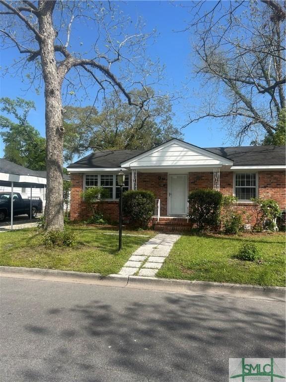 30 Lawton Ave, Savannah, GA 31404 - view of front of house with a front yard and brick siding
