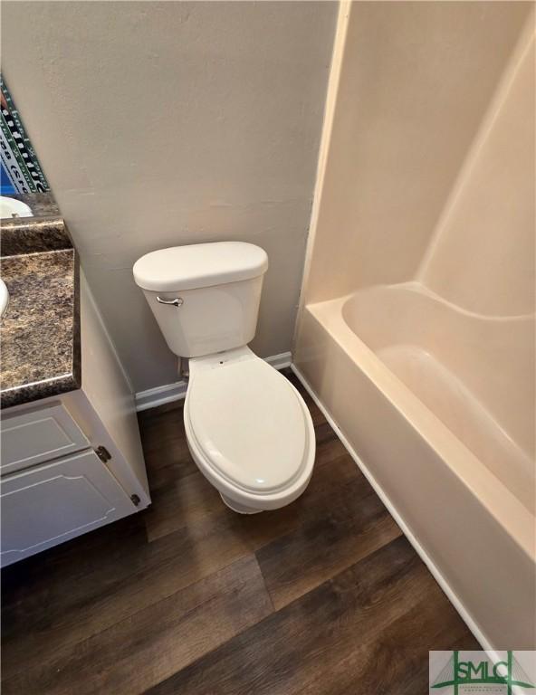 full bath featuring vanity, baseboards, toilet, and wood finished floors