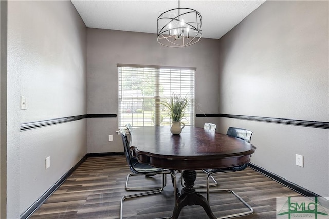 dining area featuring baseboards, a chandelier, and wood finished floors