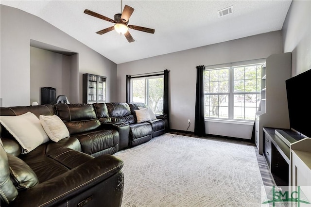 living area with a ceiling fan, visible vents, wood finished floors, lofted ceiling, and baseboards