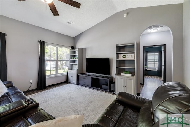 living room featuring visible vents, a ceiling fan, wood finished floors, and vaulted ceiling