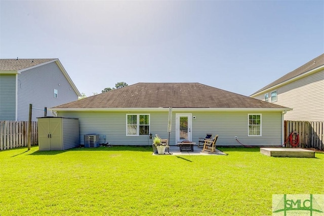 back of property with a patio area, an outdoor fire pit, a fenced backyard, and a storage unit