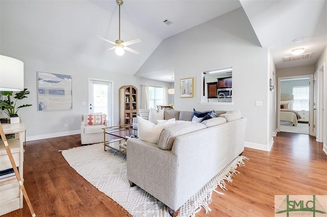 living room with light wood-style flooring, ceiling fan, baseboards, and visible vents