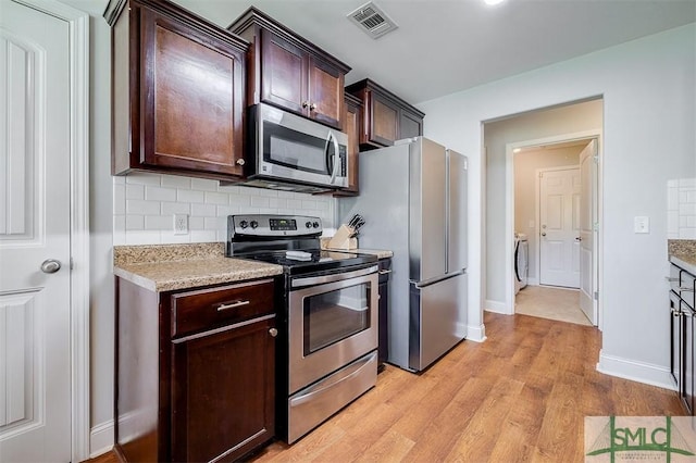 kitchen with visible vents, appliances with stainless steel finishes, light wood-style floors, dark brown cabinetry, and backsplash
