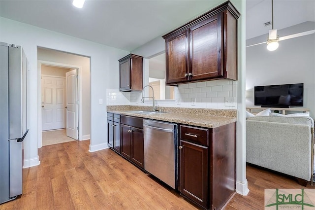 kitchen featuring dark brown cabinetry, light wood-style flooring, a sink, and appliances with stainless steel finishes