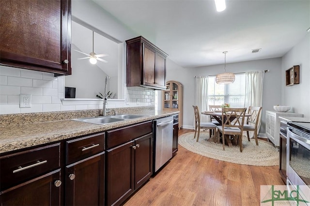 kitchen featuring light wood-type flooring, visible vents, a sink, stainless steel appliances, and decorative backsplash