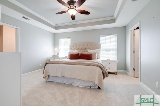 carpeted bedroom with a raised ceiling, crown molding, and visible vents