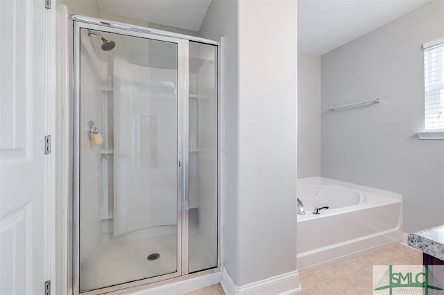 bathroom with tile patterned floors, a stall shower, baseboards, and a garden tub