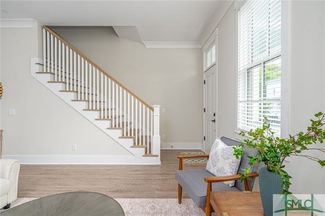 foyer entrance featuring wood finished floors, baseboards, and stairway