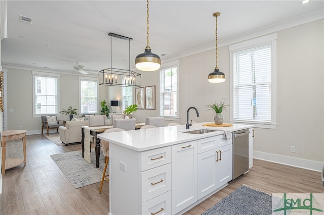kitchen with a sink, stainless steel dishwasher, an island with sink, and light wood-style flooring