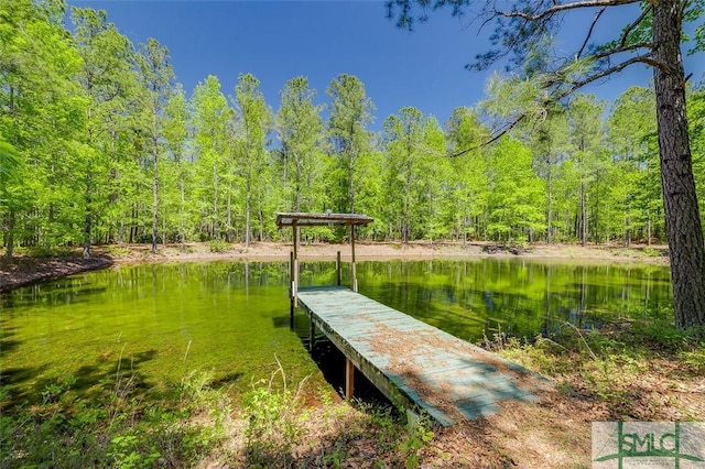 view of dock featuring a forest view and a water view