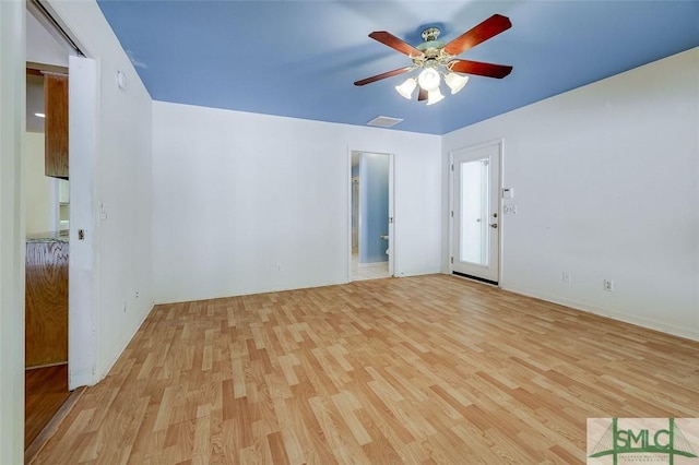 spare room featuring visible vents, a ceiling fan, and wood finished floors