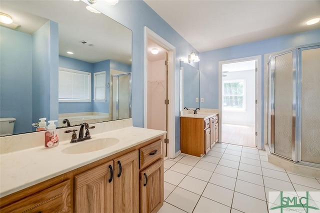 bathroom featuring two vanities, tile patterned flooring, visible vents, a sink, and a stall shower