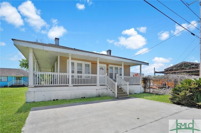 view of front of house featuring a front lawn, covered porch, crawl space, and a chimney