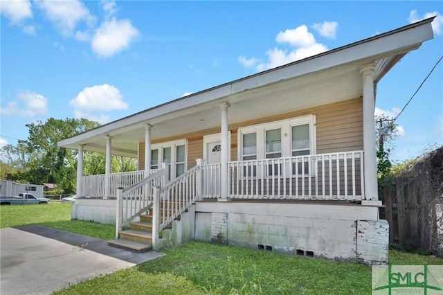 bungalow-style home with covered porch and a front yard