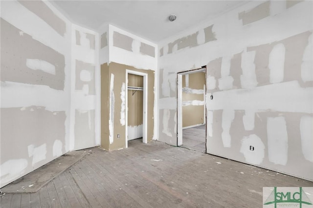 unfurnished bedroom with wood-type flooring and a closet