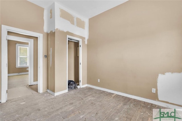 spare room with wood finished floors and baseboards