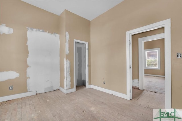 unfurnished room with baseboards and wood finished floors