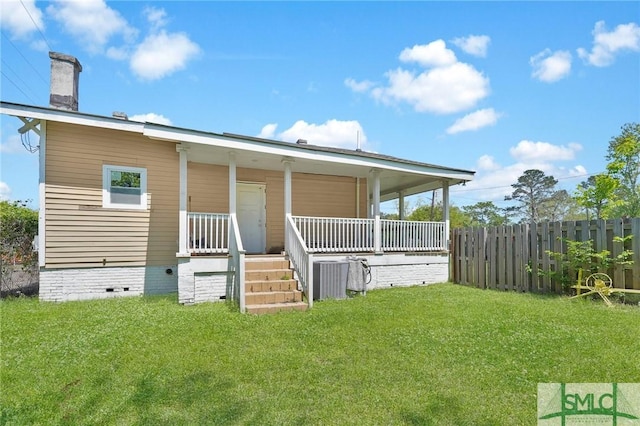 rear view of property featuring crawl space, fence, a lawn, and covered porch