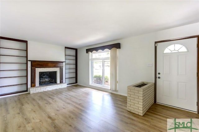 12445 Deerfield Rd, Savannah, GA 31419 - unfurnished living room with wood finished floors, a fireplace, built in shelves, and baseboards