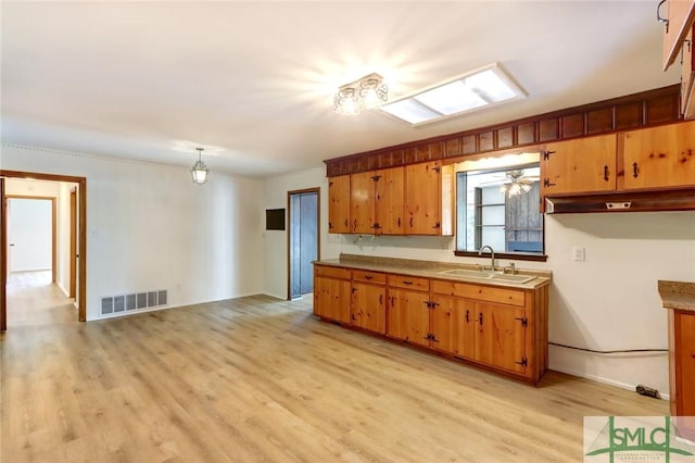 12445 Deerfield Rd, Savannah, GA 31419 - kitchen featuring a sink, visible vents, light wood-style flooring, and brown cabinets